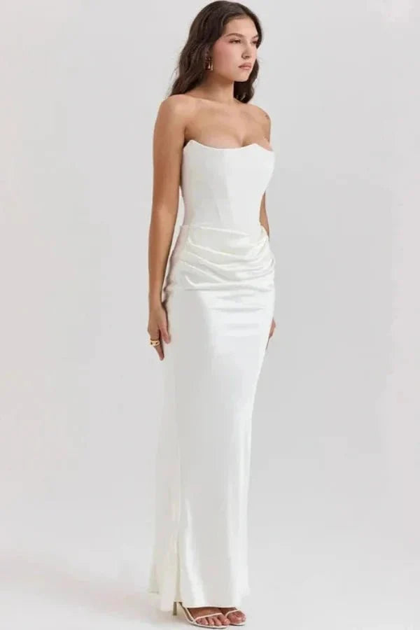 Side profile of a model in the white Zanayah formal gown by Kouvr, highlighting the draped hip and sculpted corset bodice.