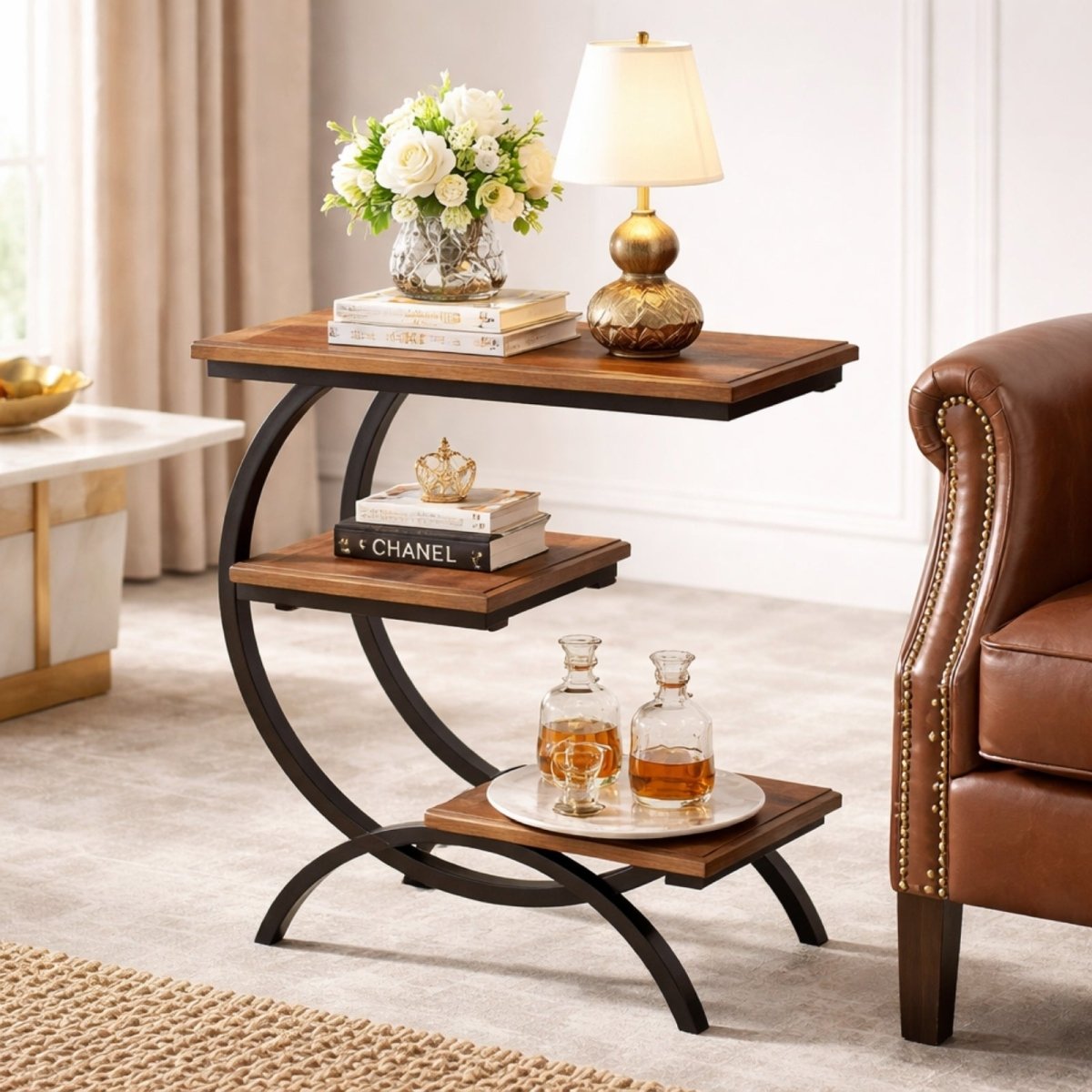 A modern living room setting featuring the Kouvr Arcadian walnut and metal side table next to a brown leather armchair with flowers and a lamp.