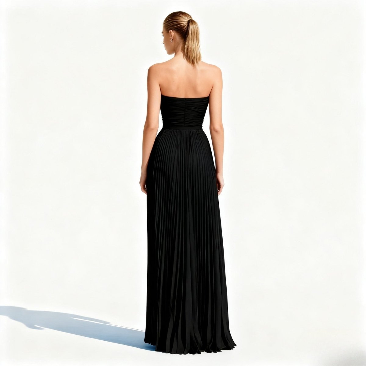 Woman wearing a black kouvr strapless gown on a white background