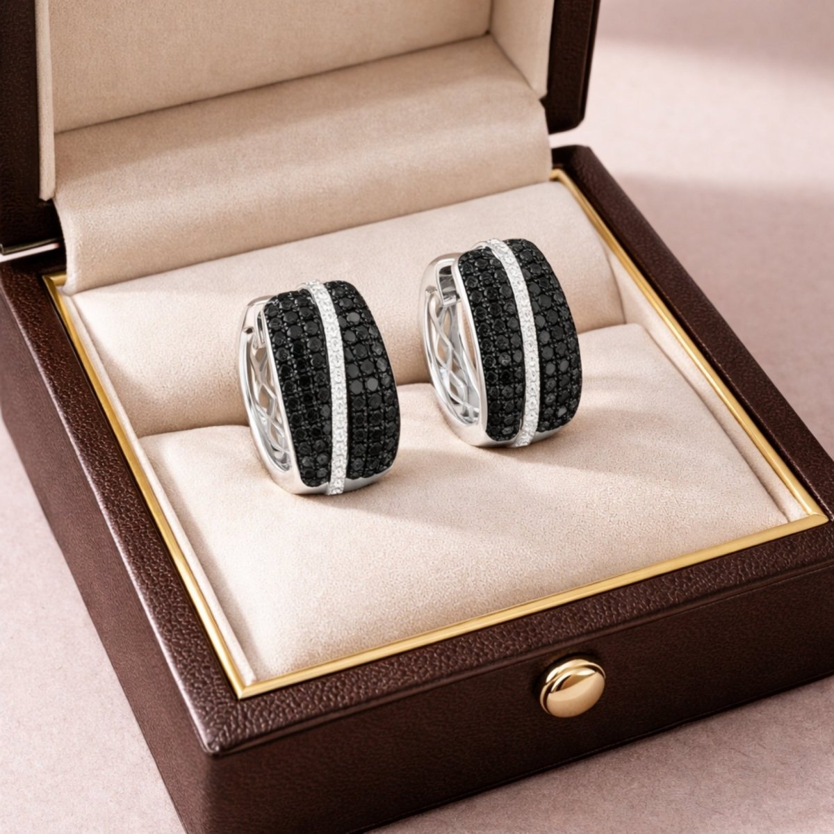 A pair of Kouvr pave diamond huggie earrings displayed in an elegant brown and cream presentation gift box.