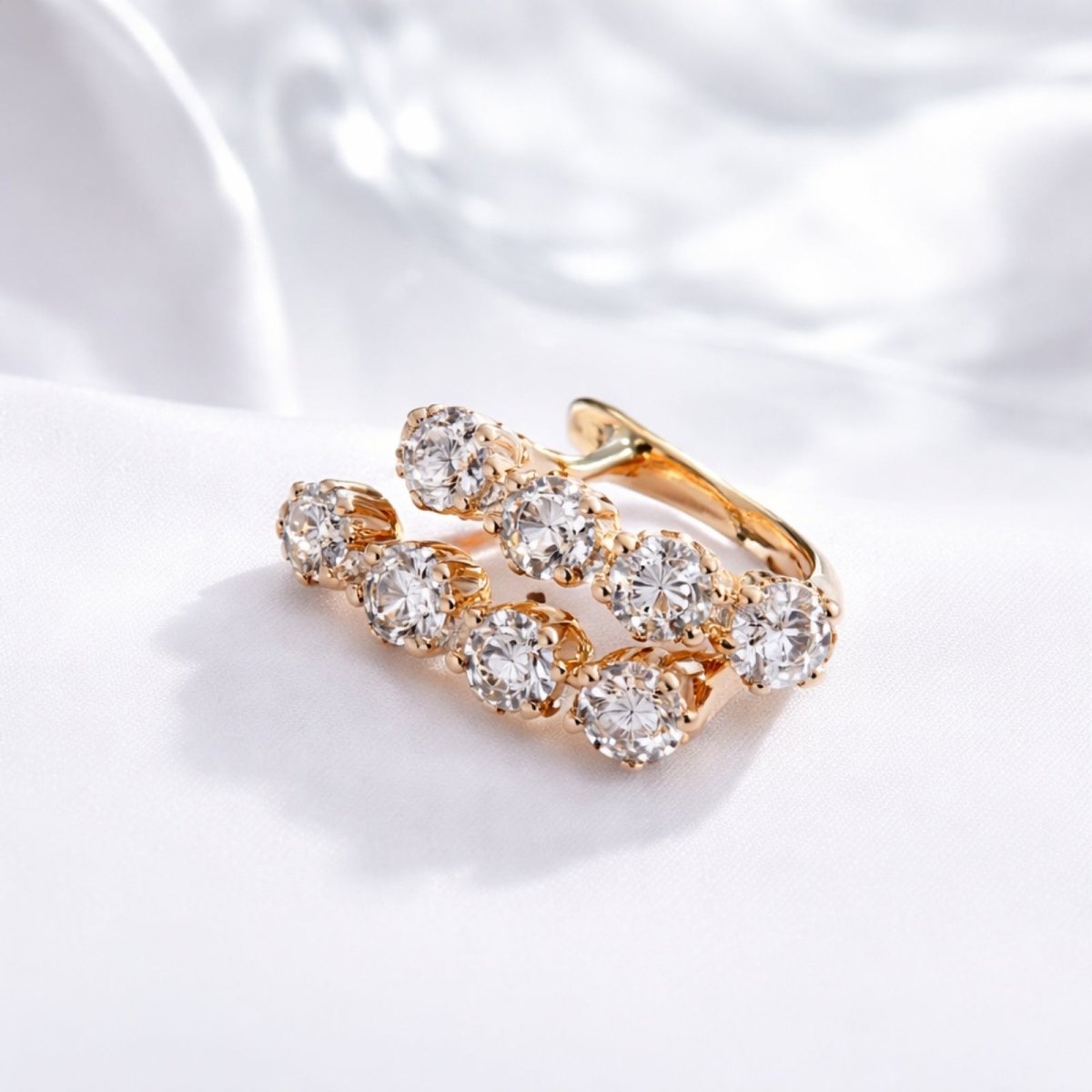 Angled close-up of Kouvr's four-stone zircon cluster earrings, showing the brilliant faceting of the stones and the warm tone of the 14k rose gold.