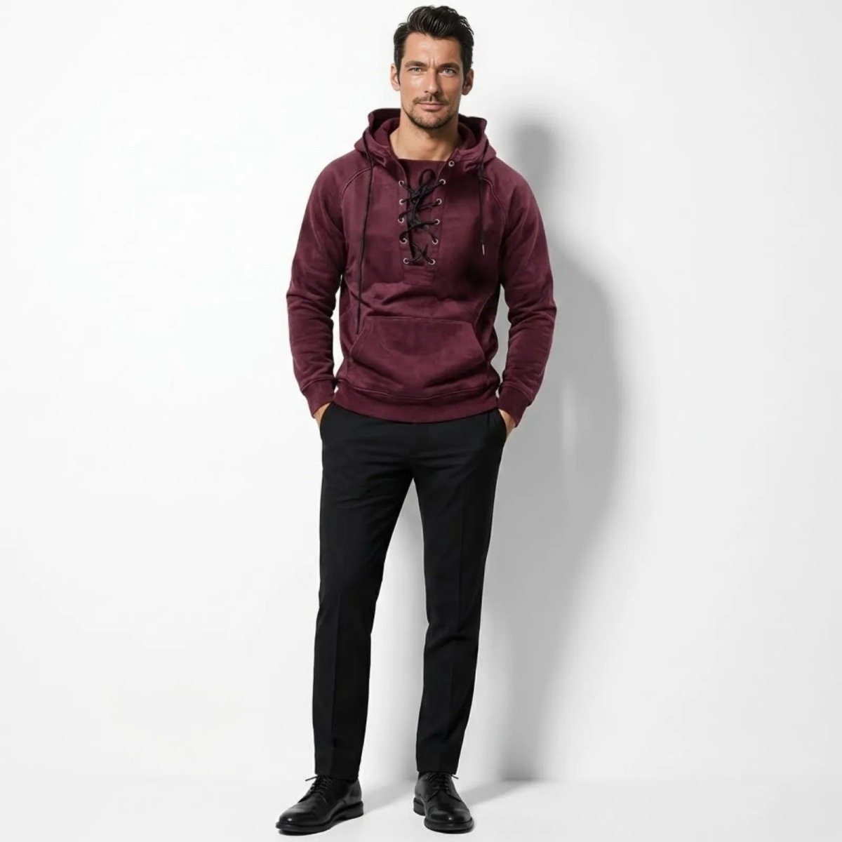 Male model wearing the Kouvr burgundy lace-up velour hoodie paired with black tailored trousers, showing the front view.