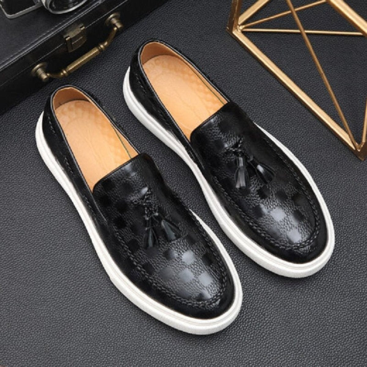 Close-up detail shot of the embossed checker pattern and hand-stitched moc toe on the black Kouvr Carlo tassel loafer.
