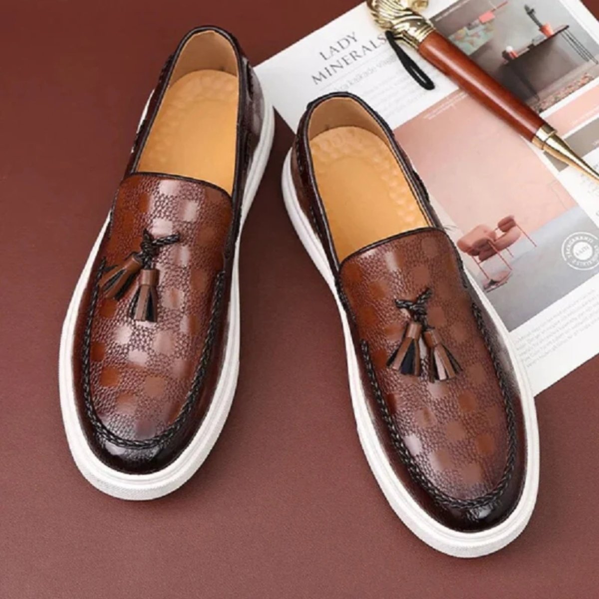 Close-up detail shot of the embossed checker pattern and hand-stitched moc toe on the black Kouvr Carlo tassel loafer.