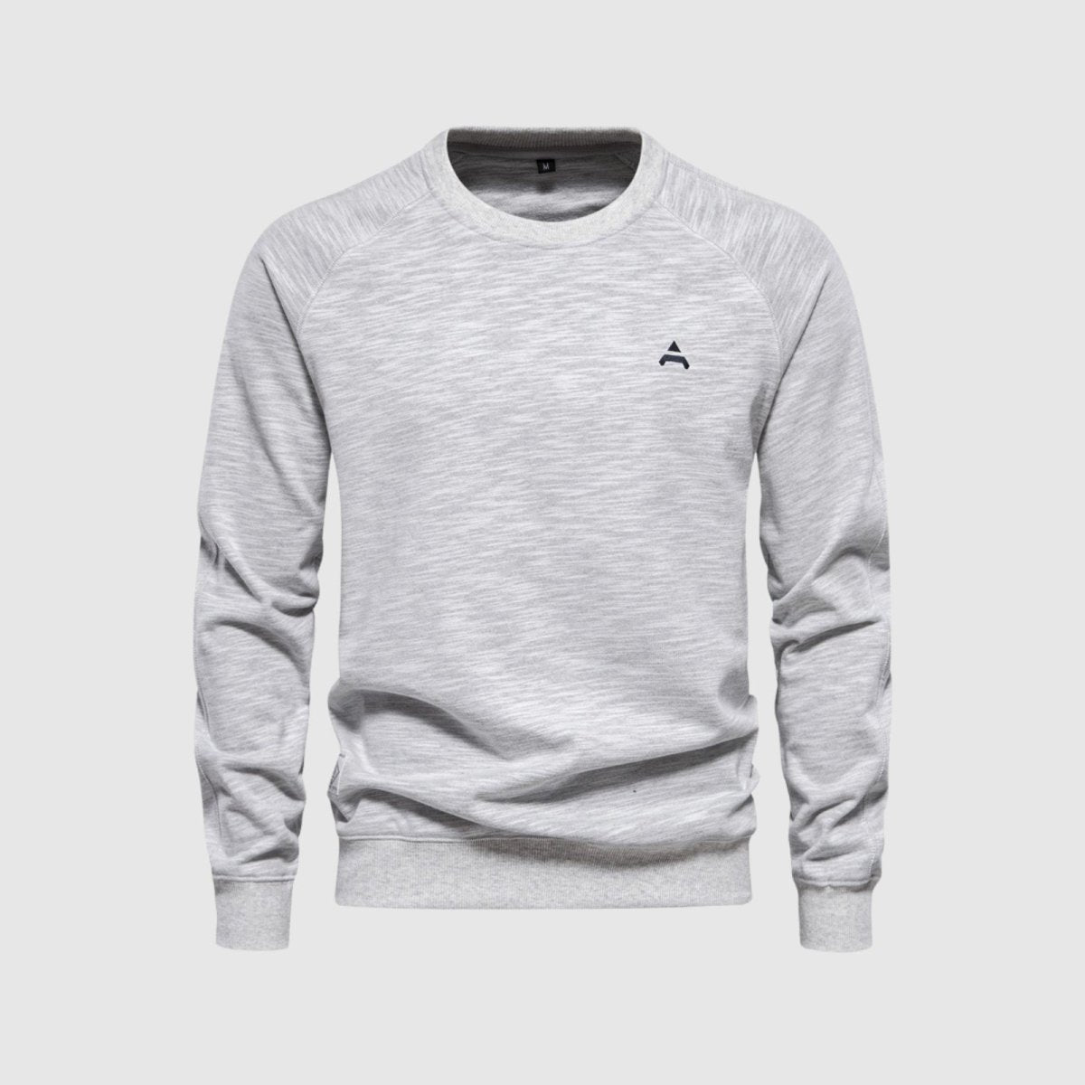 Studio product shot of the Kouvr Deacon Crewneck Sweatshirt in heather light grey, showing fabric texture and the embroidered logo in detail.