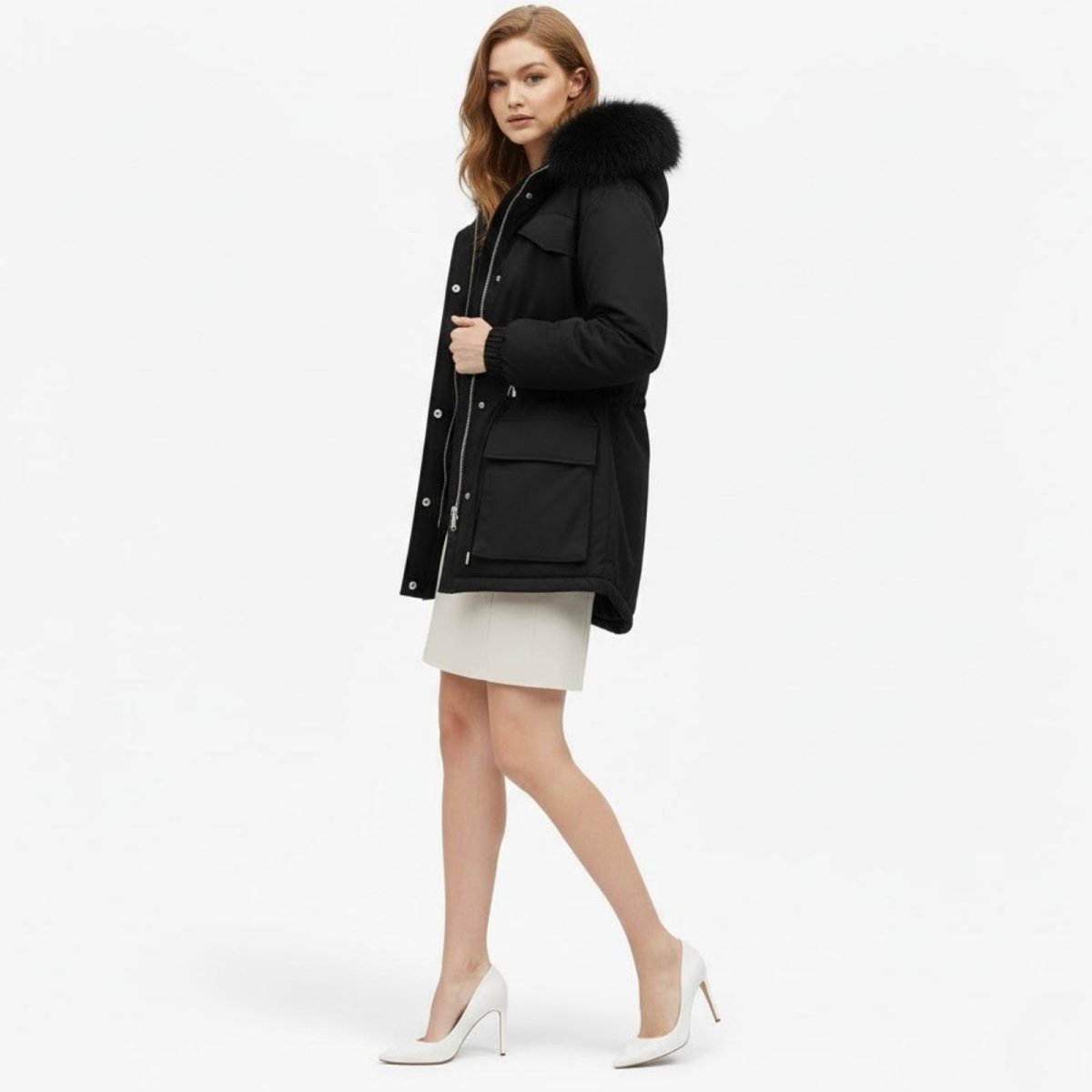 Side profile of a woman wearing the Kouvr Fashion Debra insulated black winter parka, showcasing its mid-thigh length and the volume of the faux fur trim on the hood.