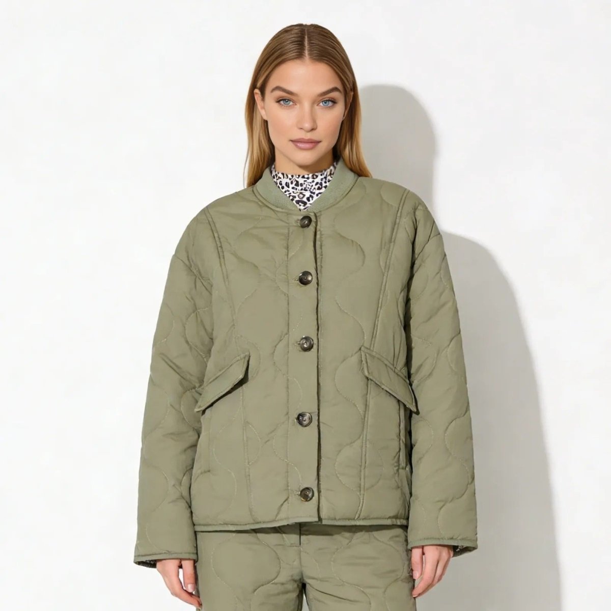 Model wearing the Kouvr Fashion oversized quilted liner jacket in army green, styled with a leopard print mock neck top and matching green trousers.