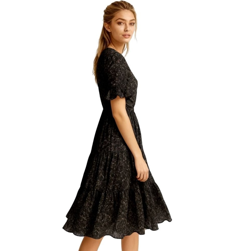 Woman wearing a kouvr black floral dress on a white background