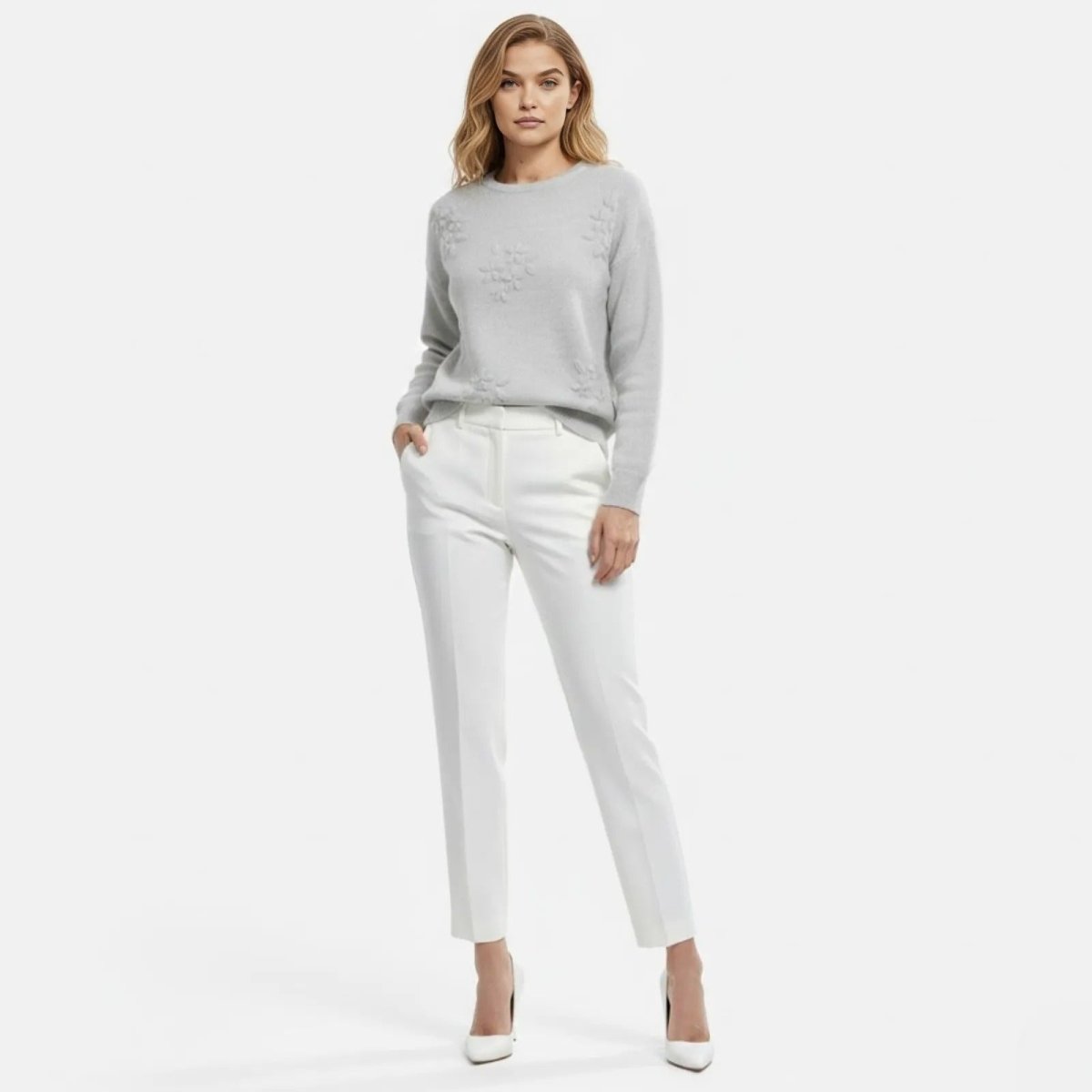 Model wearing the Blanche 3D Floral Appliqué Sweater in light grey, styled with white trousers, shown from the front.