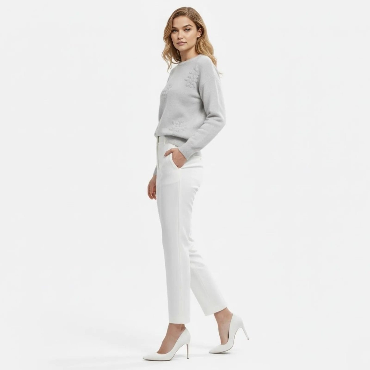 Model in a side profile view wearing the Blanche 3D Floral Appliqué Sweater in light grey to show the sleeve and side detailing.