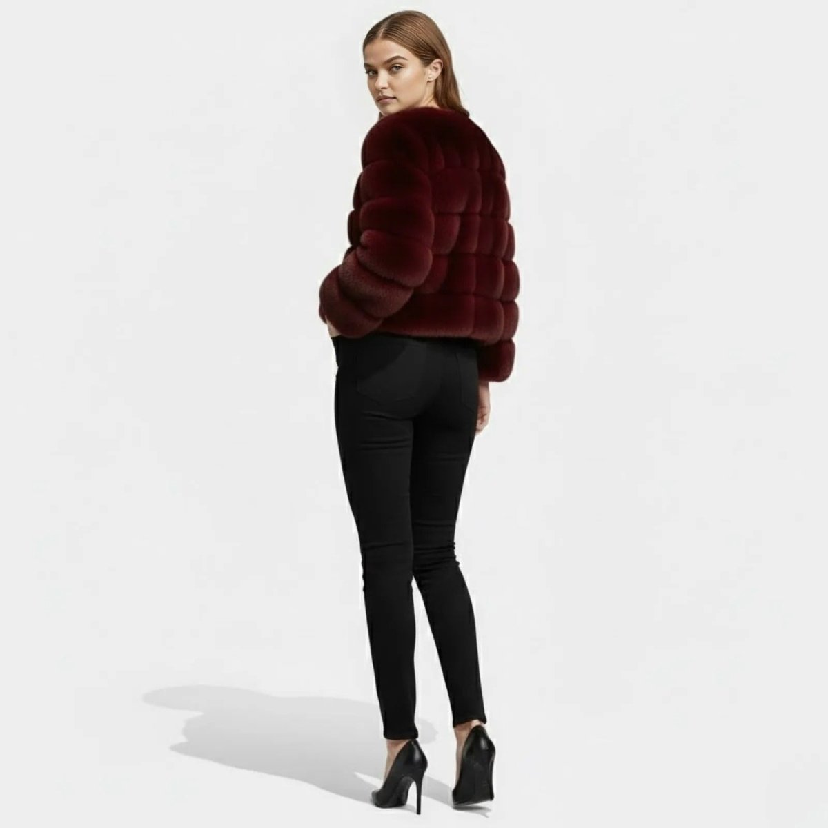 Back view of the collarless ruby red faux fur evening jacket showing the horizontal panel construction.