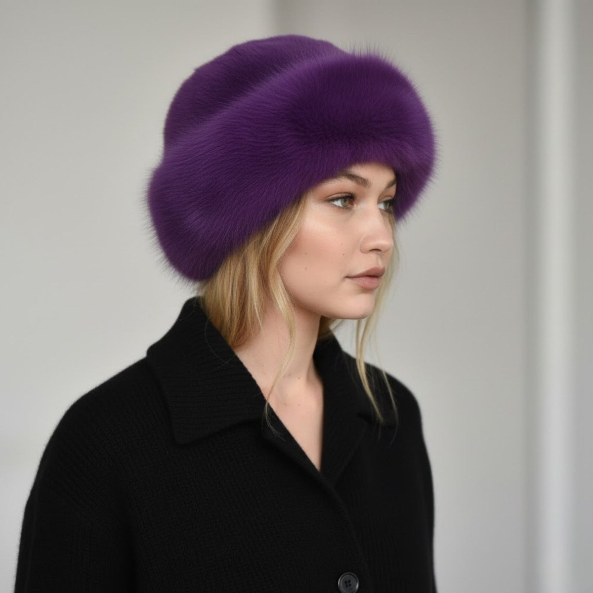 Woman wearing a purple fur hat and black coat against a plain background