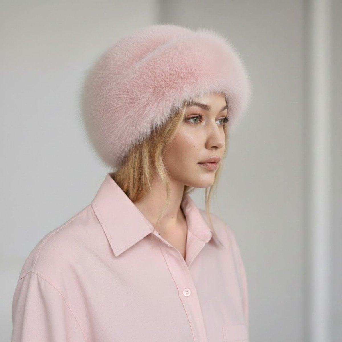 Woman wearing a pink fur hat and shirt against a light background