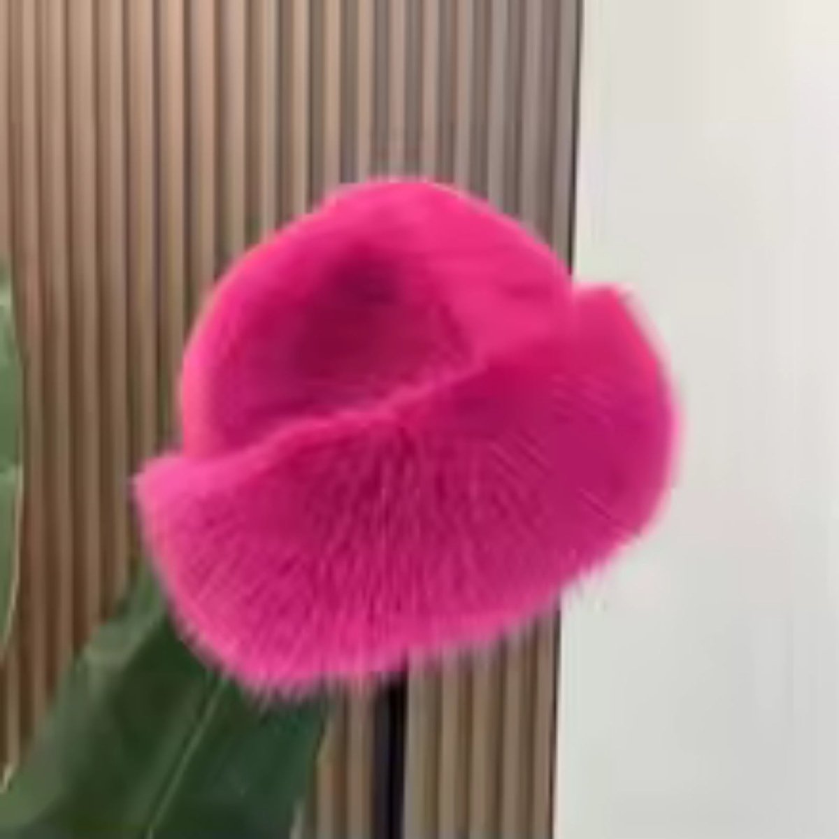 Pink fluffy object against a neutral background