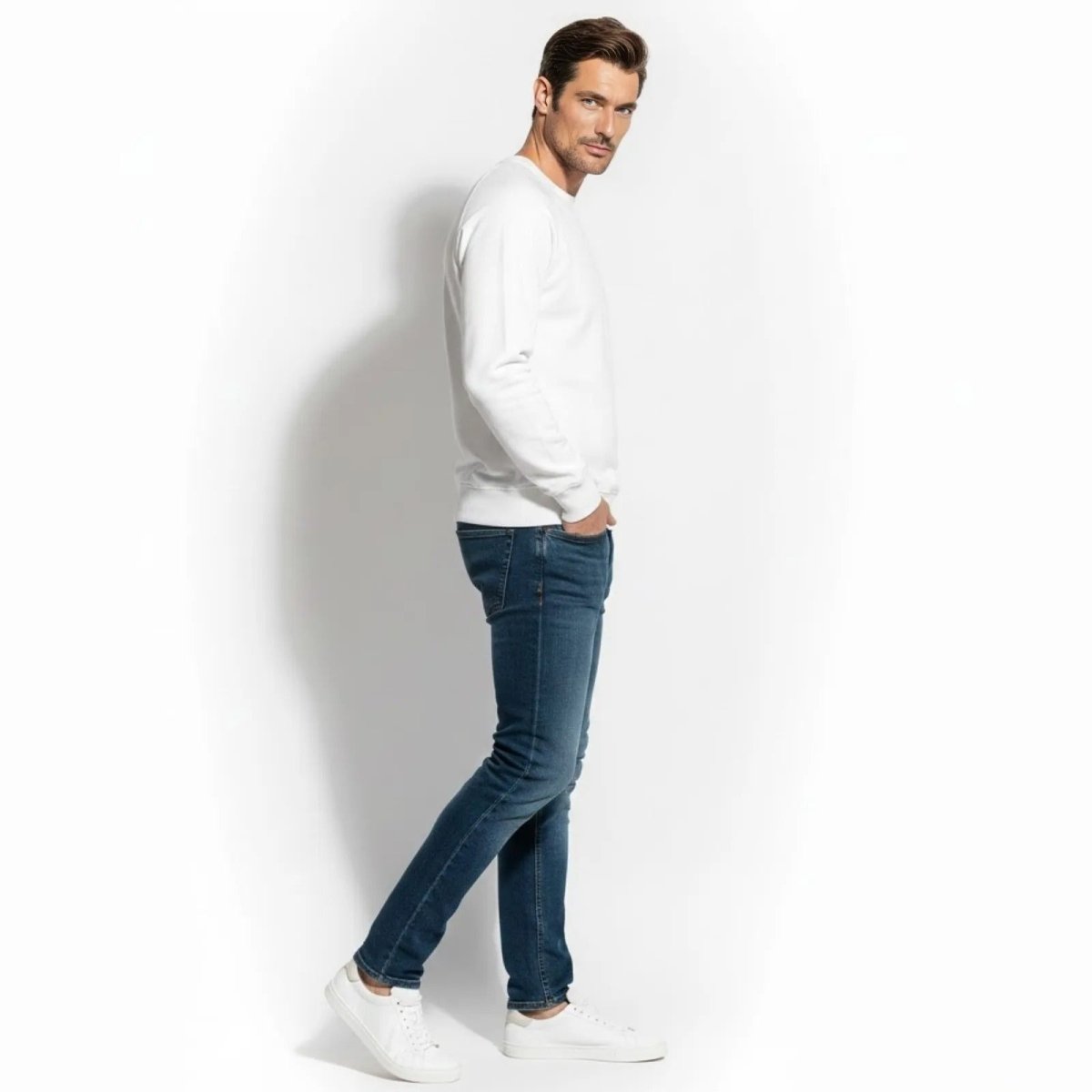 Side profile of a man in the slim fit white luxury sweatshirt from Kouvr Fashion.