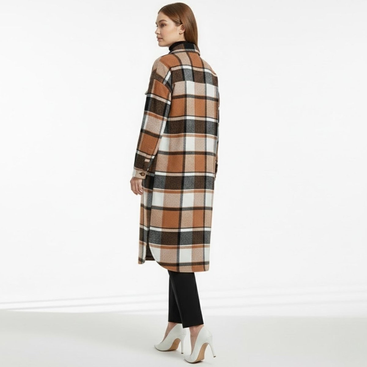 Back view of a woman wearing an oversized khaki and black plaid coat, showcasing the full pattern and relaxed fit.