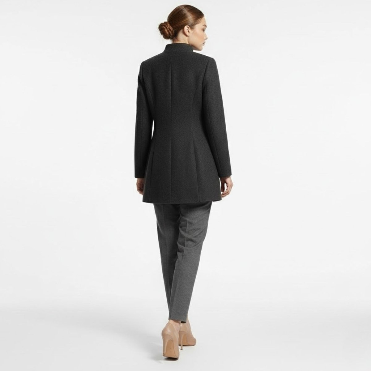 Back view of the Kouvr structured dark grey wool coat on a model, highlighting the clean vertical seams and sophisticated A-line shape.