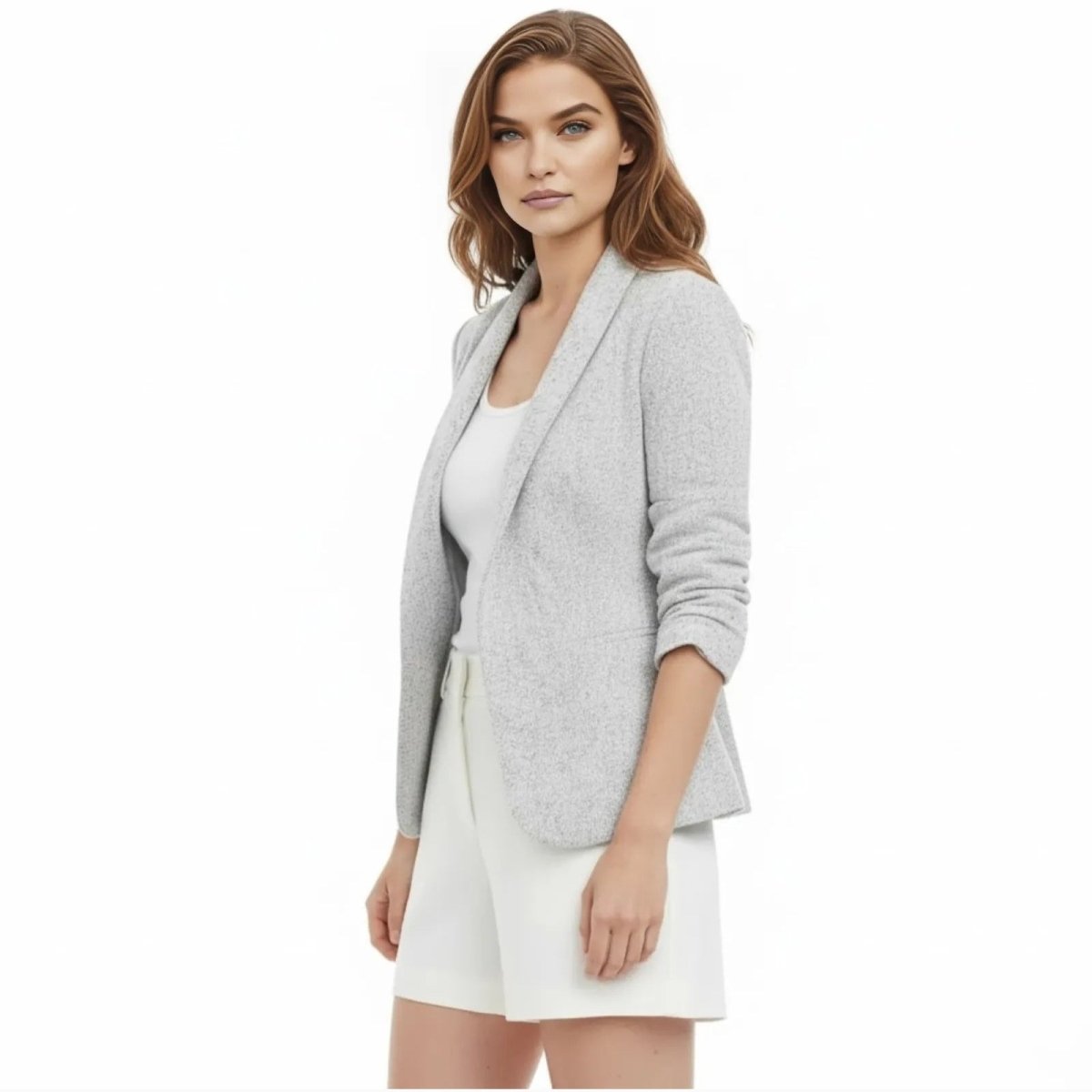Side profile of a female model in the light grey Kouvr Geraldine Knit Blazer showing the three-quarter ruched sleeve detail.