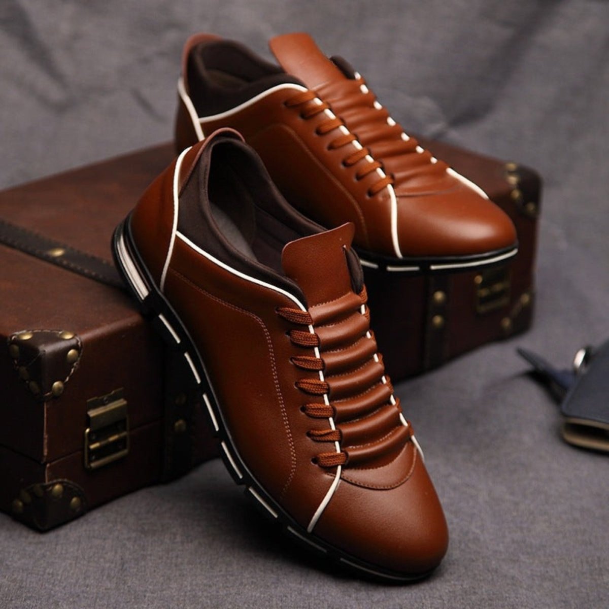 A pair of classic brown leather Kouvr Jimmy men's sneakers, showcasing the detailed stitching and unique cushioned tongue design.