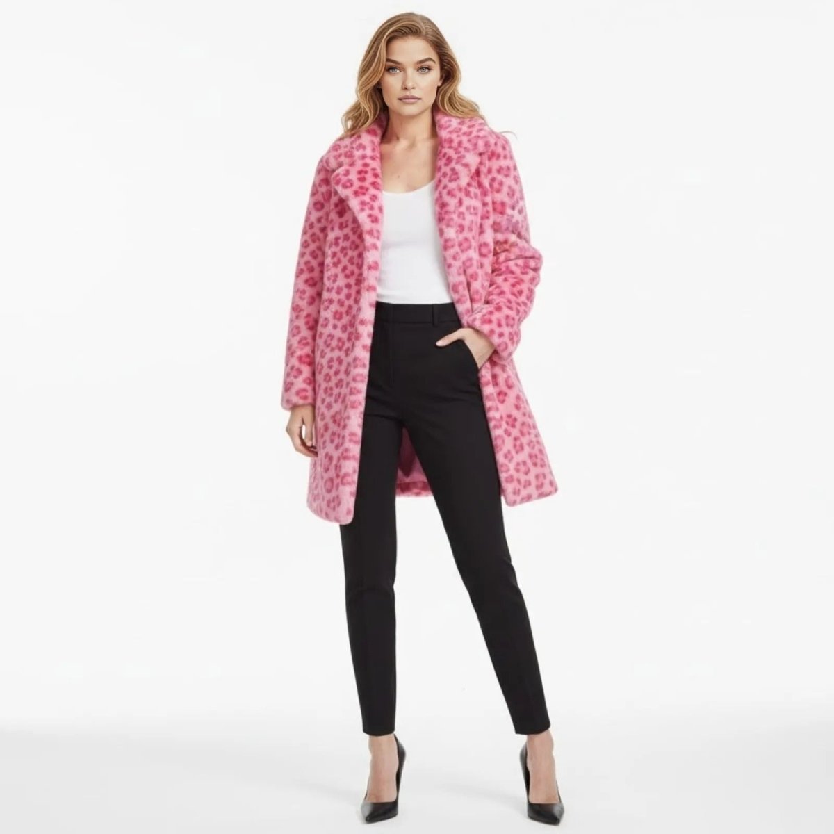 Model facing forward wearing the Kouvr Jovi pink leopard print faux fur coat paired with a white top and black trousers.