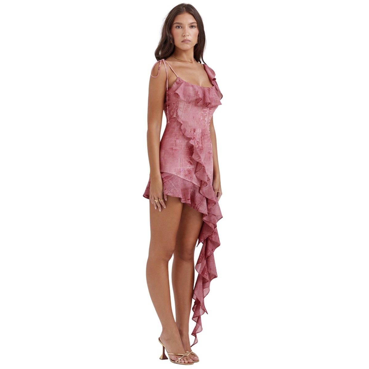 Woman wearing a pink kouvr ruffled dress on a white background