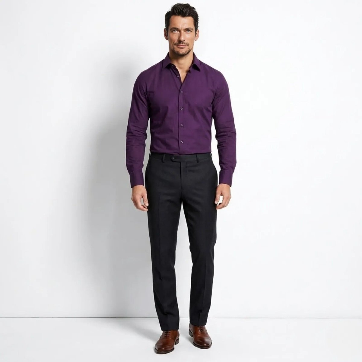 Male model wearing the Kouvr Leland slim fit long sleeve dress shirt in purple, paired with black trousers and brown shoes, standing front-on.