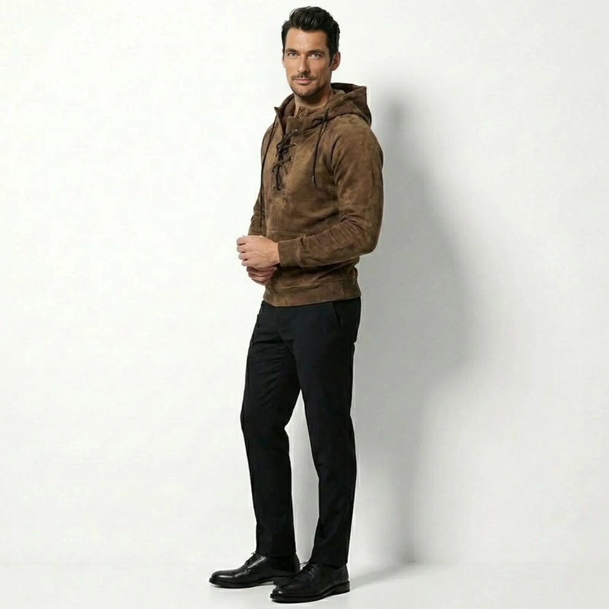 Side profile of a model in the Kouvr khaki suede hooded sweatshirt with lace-up detail.