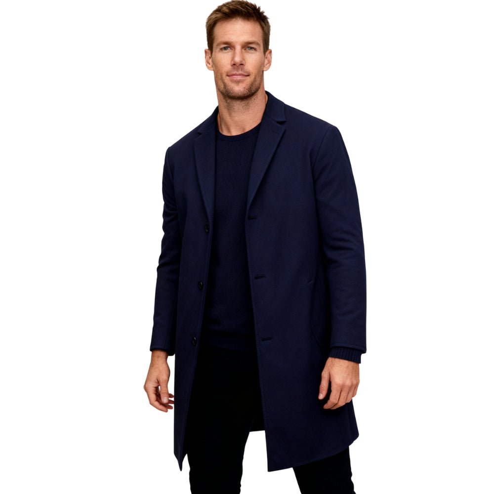 Man wearing a navy blue Kouvr coat on a white background
