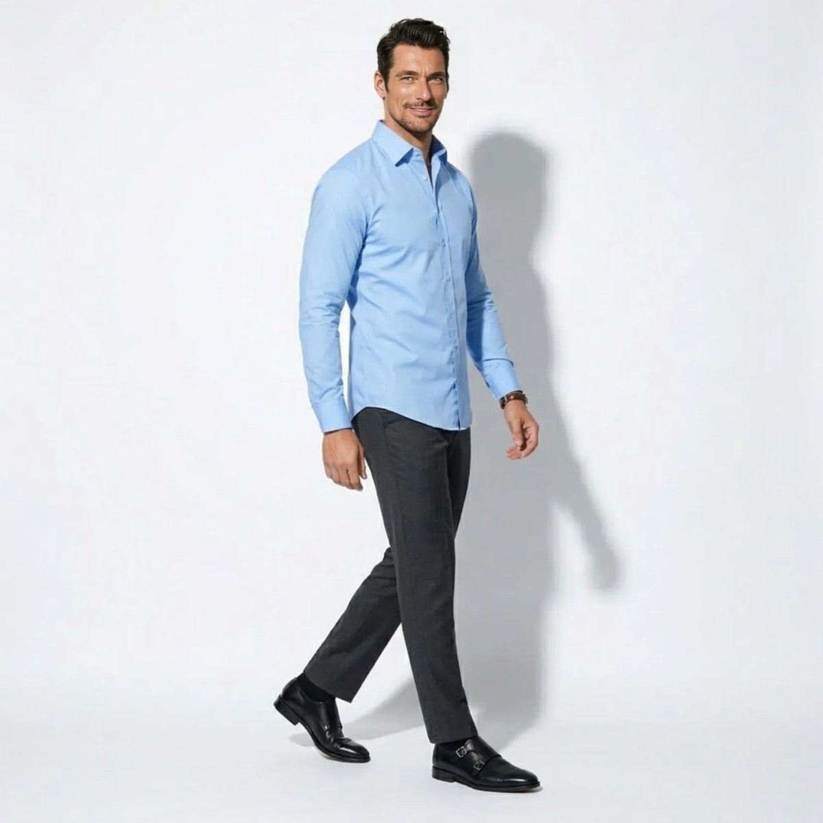 Side profile of male model walking in Kouvr premium cotton sky blue dress shirt.