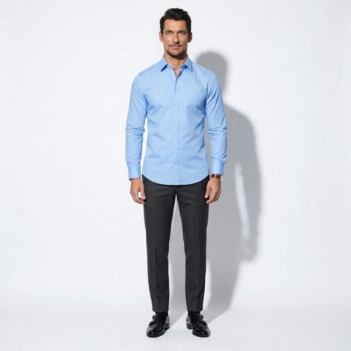 Front view of male model wearing Kouvr sky blue tailored fit dress shirt with dark grey trousers.