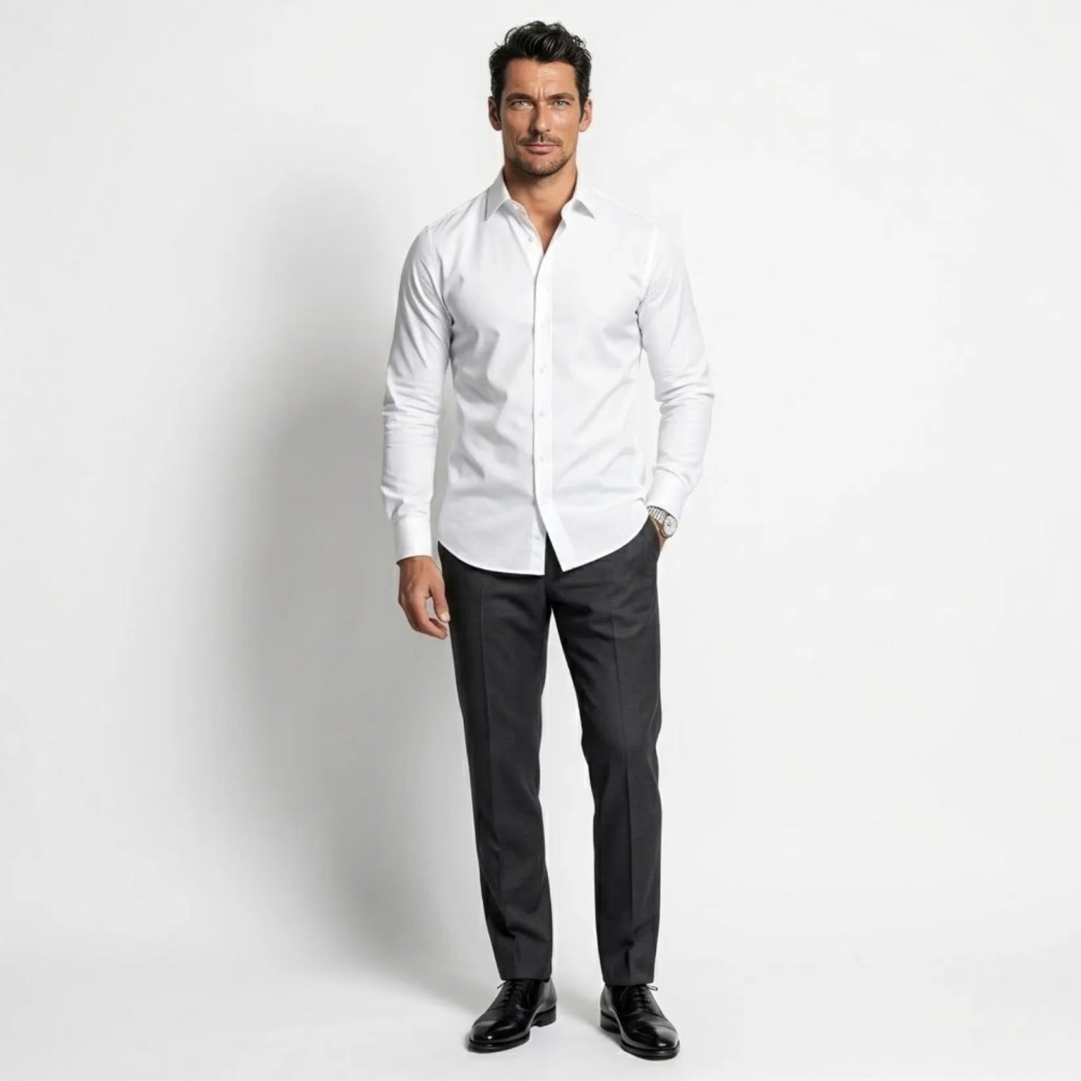 Man standing confidently wearing Kouvr premium tailored white dress shirt tucked into dark trousers