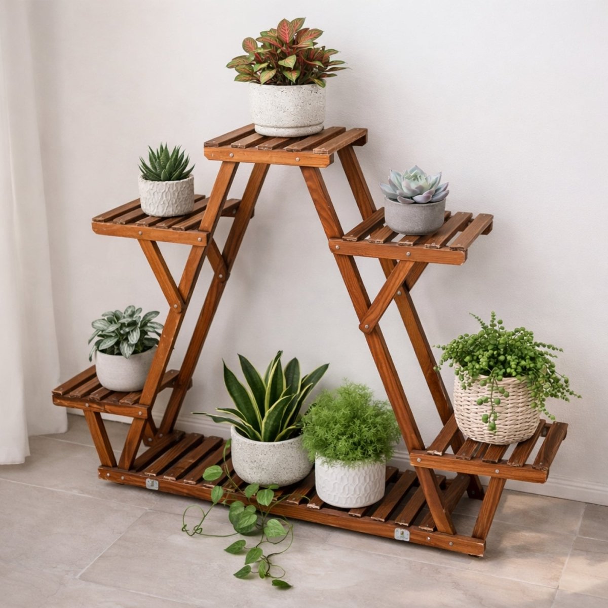 A minimalist arrangement on the Kouvr wooden plant holder, featuring various succulents and a snake plant in stylish ceramic pots against a white wall.