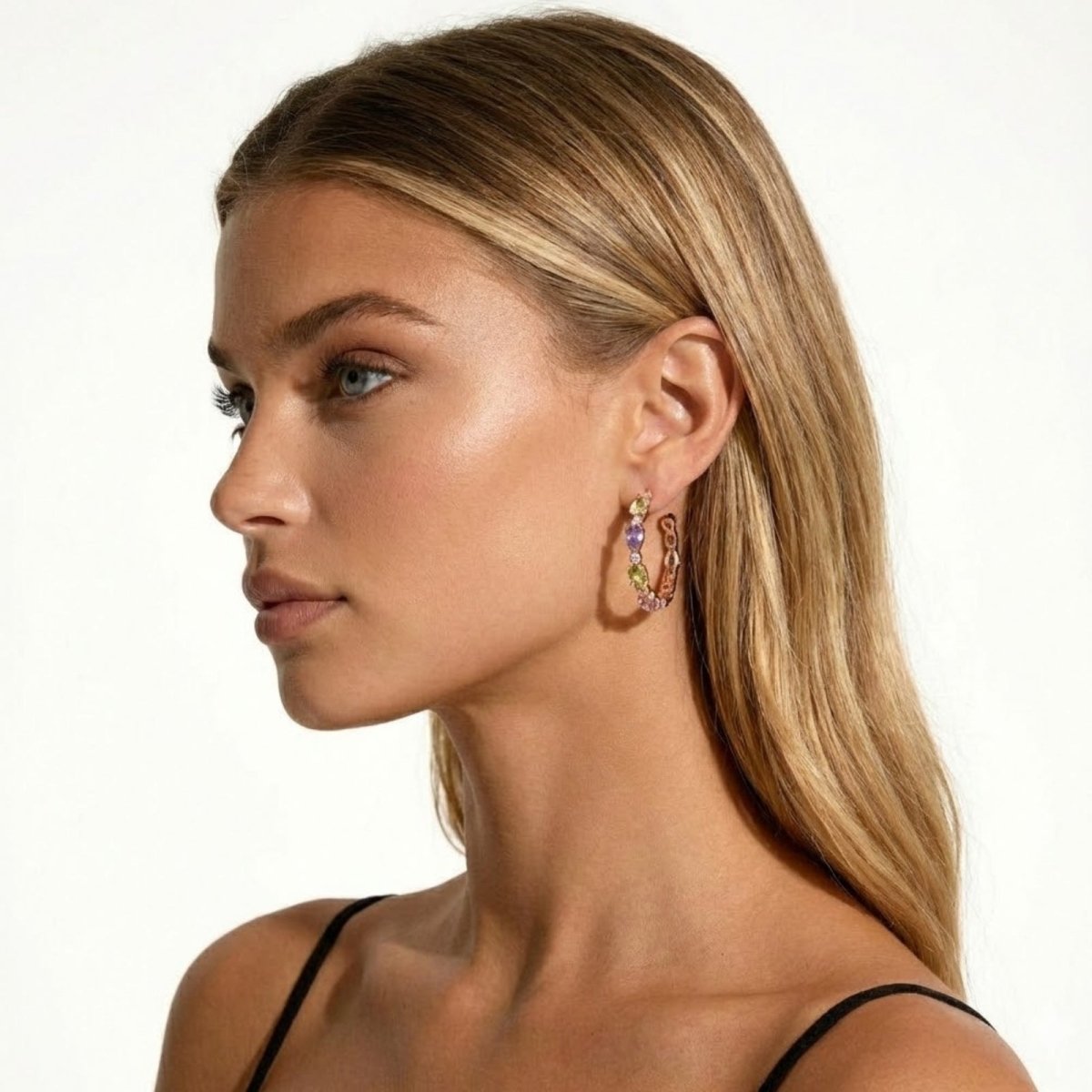 Side profile of a model showcasing the detail of the Kouvr Raelynn rose gold and multi-gemstone hoop earring in her ear.