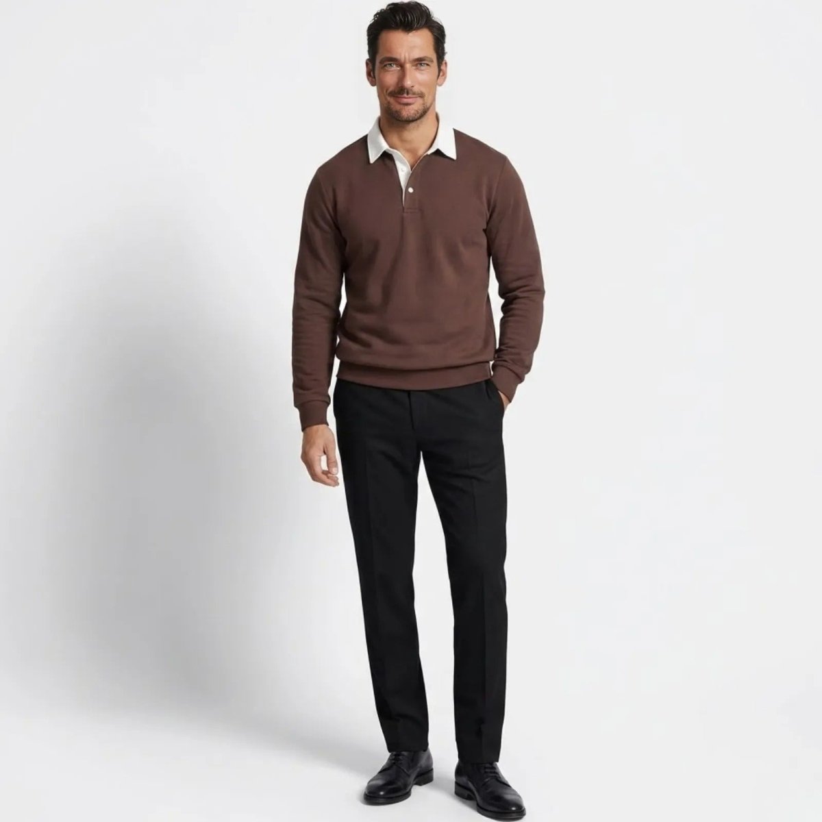 Man wearing the Kouvr Rhodes dark brown long sleeve knit polo sweater with a white contrast collar, styled with black tailored trousers.