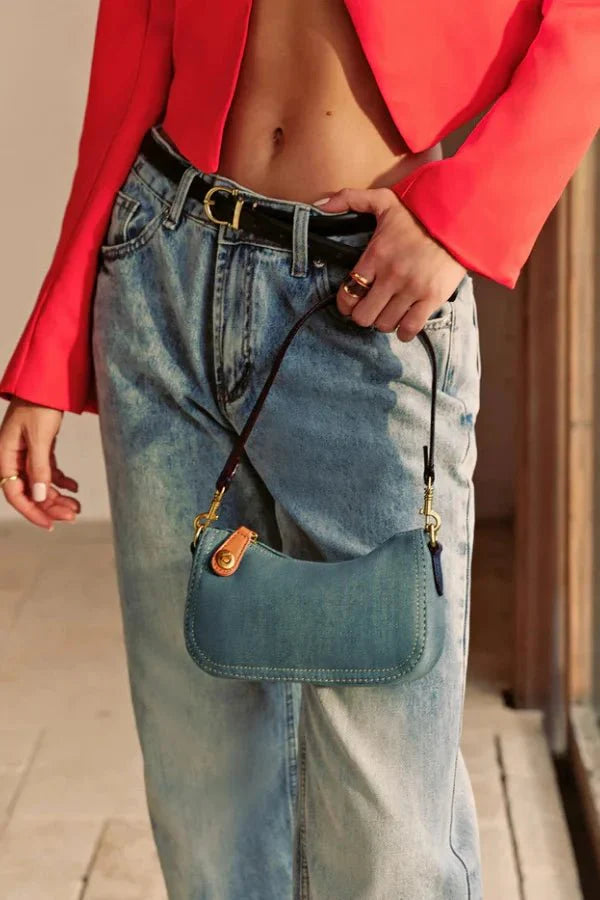 Close-up detail of the gold turn-lock clasp and contrast stitching on the Kouvr Romy denim bag.