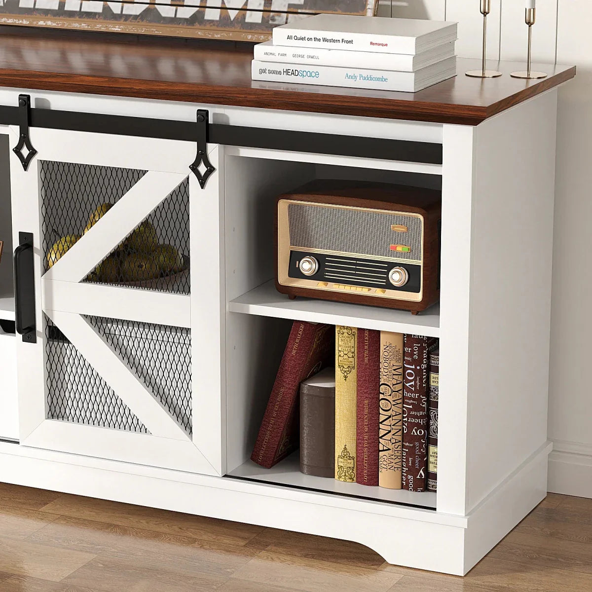 The side cabinet of the Kouvr rustic TV stand with the barn door slid open, displaying a vintage radio and books on an adjustable shelf.