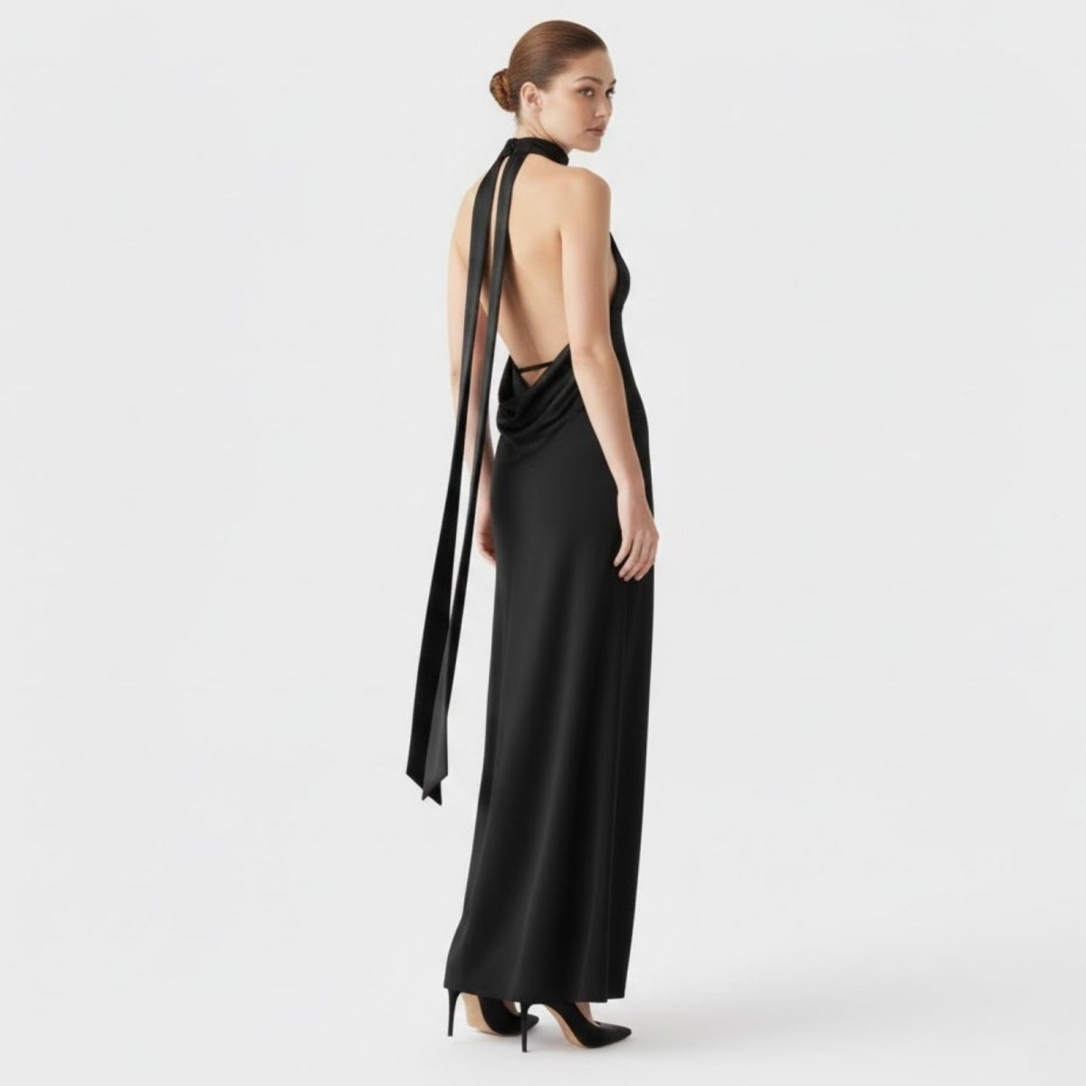 Back view of the Kouvr Sharon gown, showcasing the dramatic open back, draped cowl detail, and long flowing neck ties.