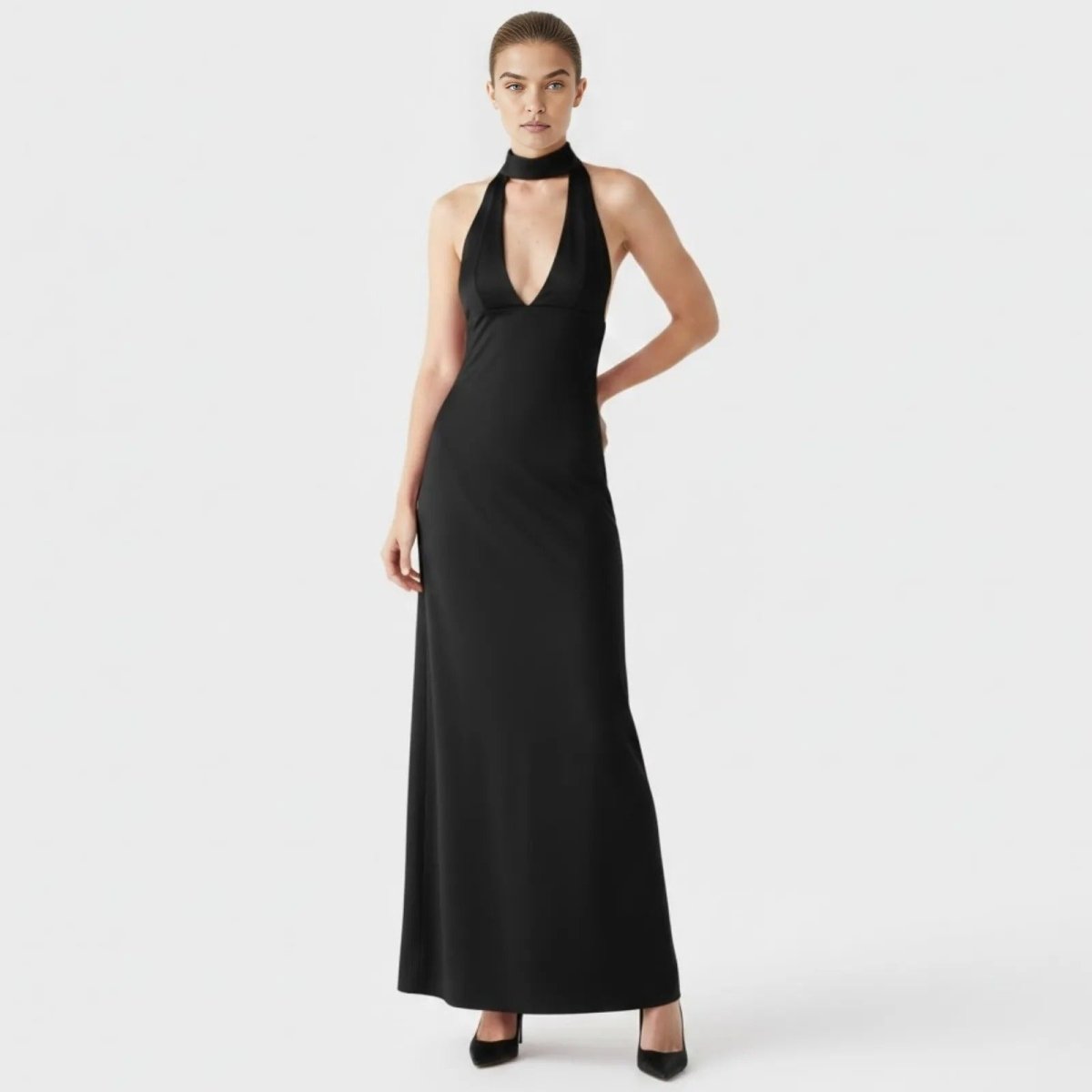Model wearing the Kouvr Sharon black halter neck maxi gown, showing the plunging V-neck and choker collar from the front.