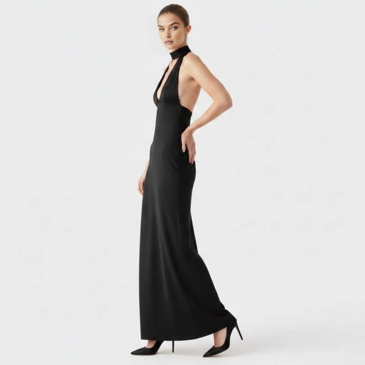 Side profile of a model in the Kouvr Sharon black formal gown, highlighting the sleeveless design and body-skimming silhouette.