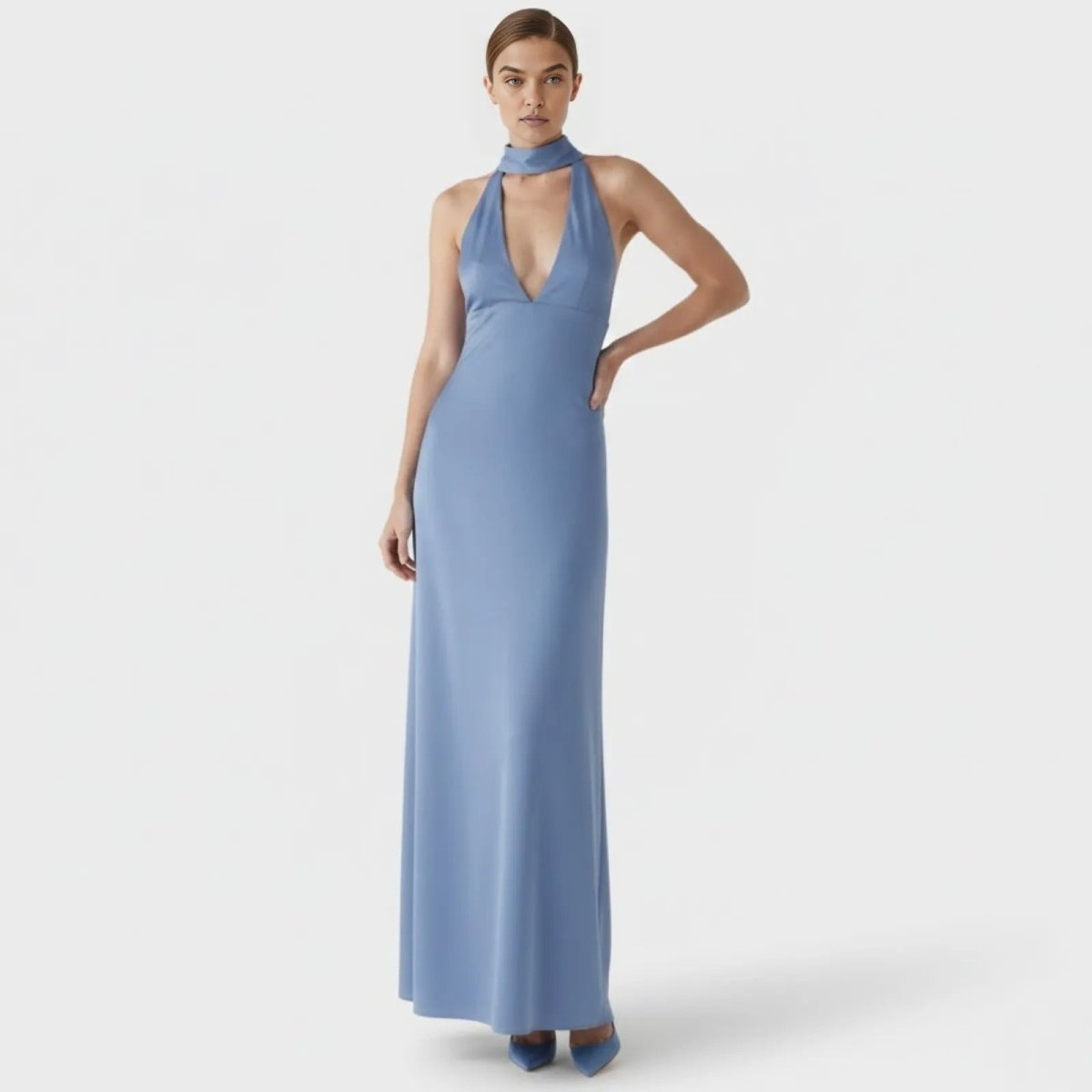 Model wearing the Kouvr Sharon halter neck maxi gown in cornflower blue, showing the plunging v-neckline and full length from the front.