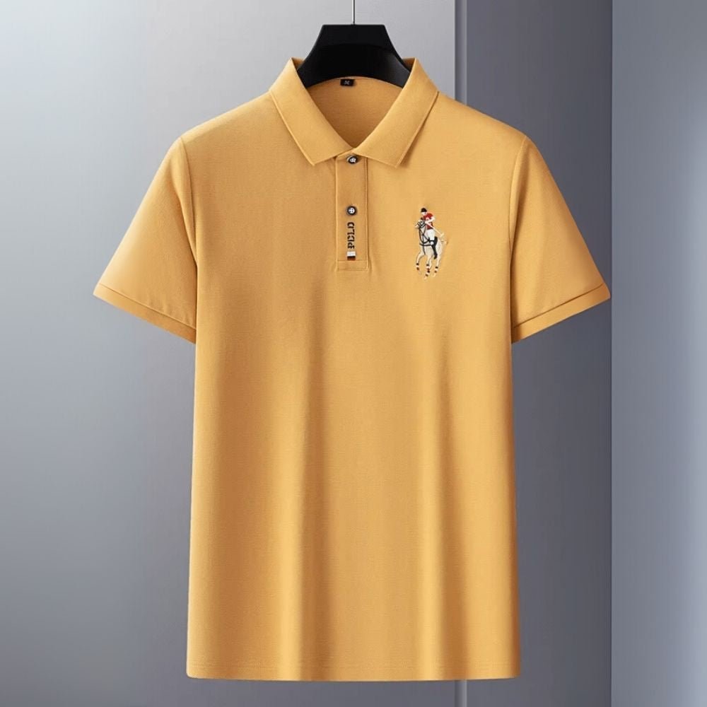Yellow kouvr polo shirt with a logo on a gray background