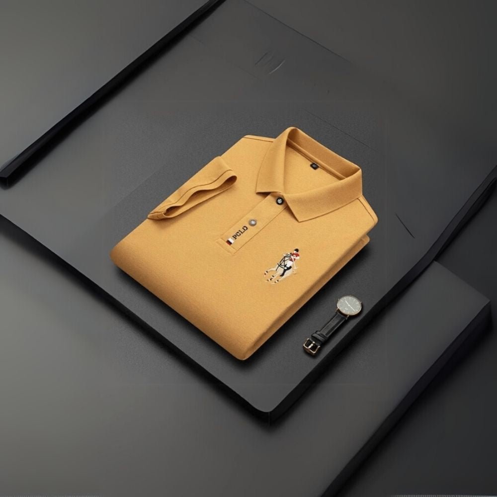 Yellow kouvr polo shirt with a brand logo on a dark surface