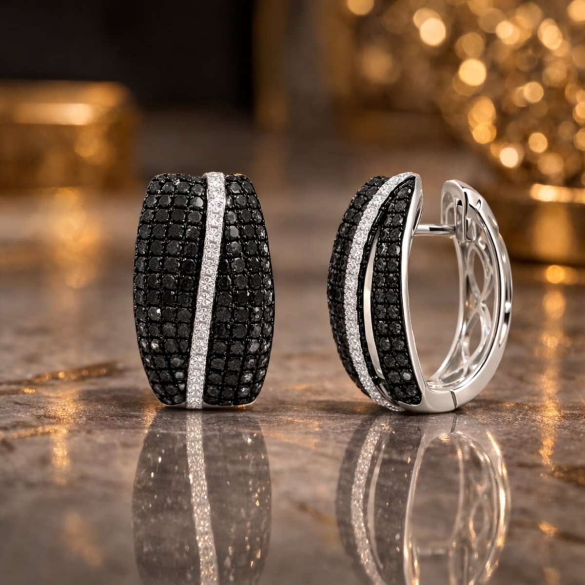 Close-up detail of Kouvr's black and white diamond huggie hoop earrings with their reflection on a marble surface, showing craftsmanship.