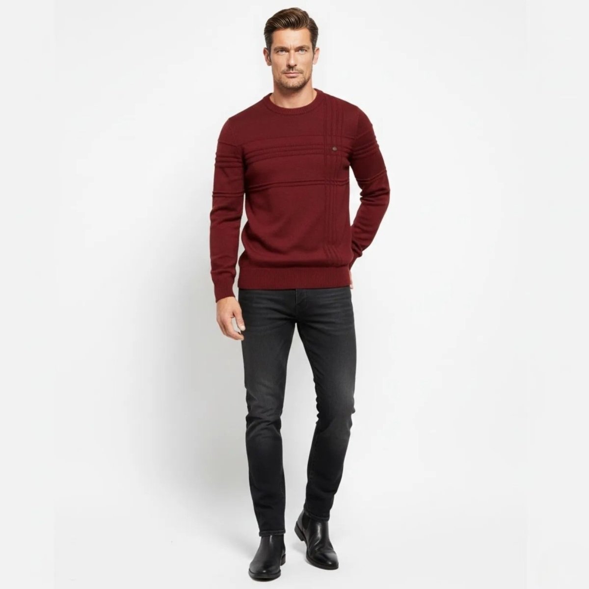 Male model wearing the Kouvr red textured crewneck sweater and black jeans, standing front-on against a white background.