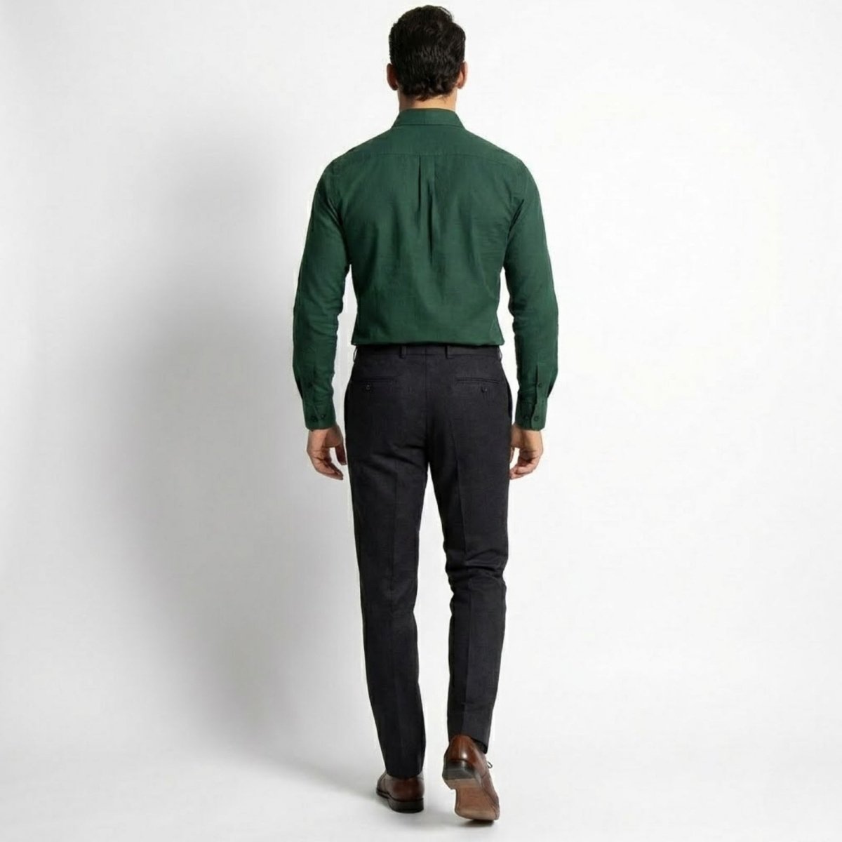 Back view of a model in the Kouvr Leland dark green shirt, highlighting the back yoke, box pleat, and slim silhouette.