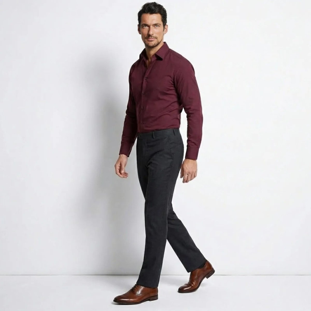 Side profile view of a man in a Kouvr slim fit burgundy button-down shirt showing its tailored fit.