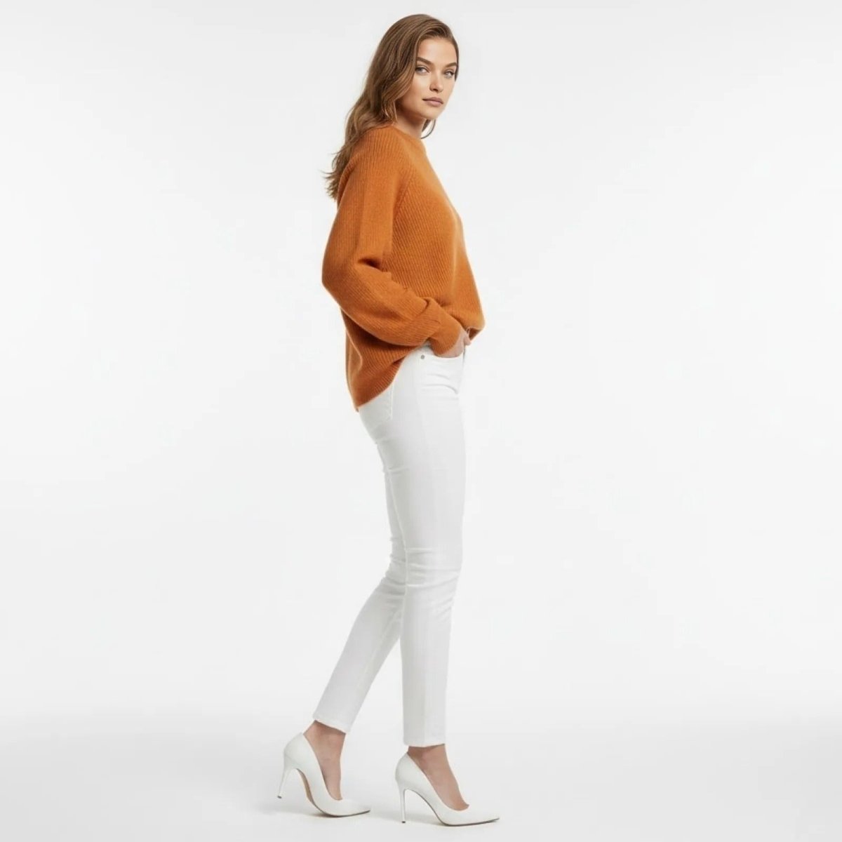 Side profile of a model in a burnt orange merino wool cashmere blend sweater showing the relaxed fit and dolman sleeve detail.