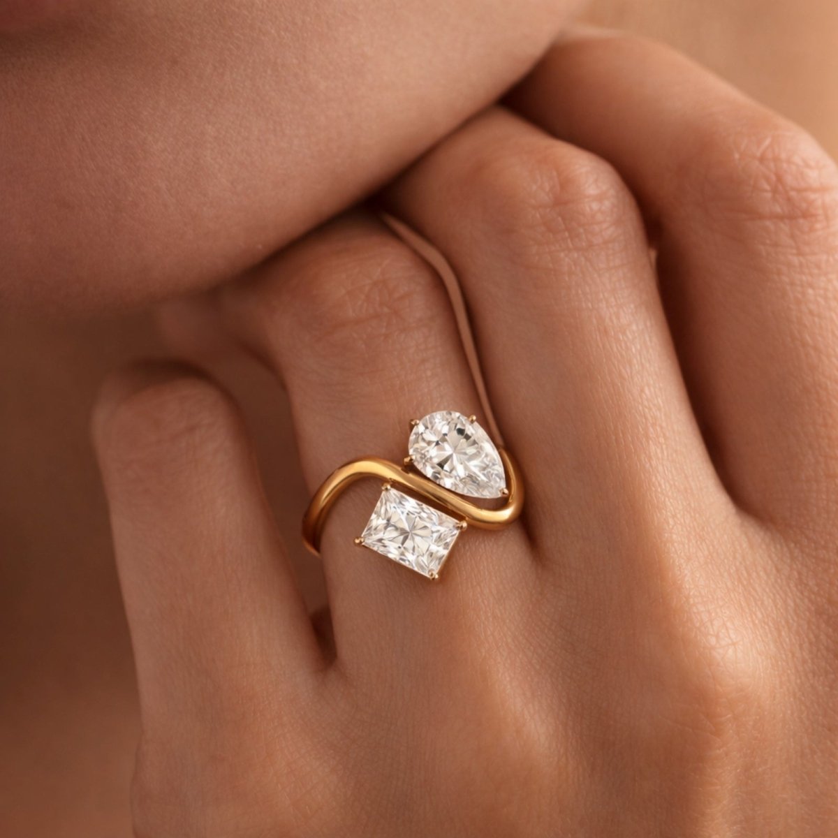 A close-up lifestyle image of the Kouvr Toi et Moi diamond engagement ring on a model's finger, highlighting its elegant proportions.