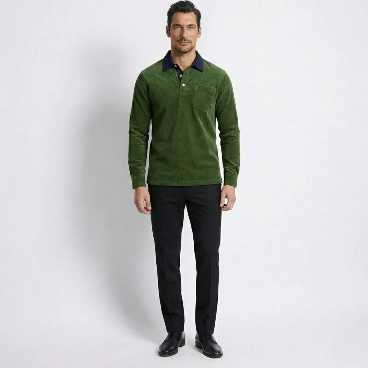 Model wearing the Kouvr Zian long sleeve corduroy polo shirt in olive green with black trousers.