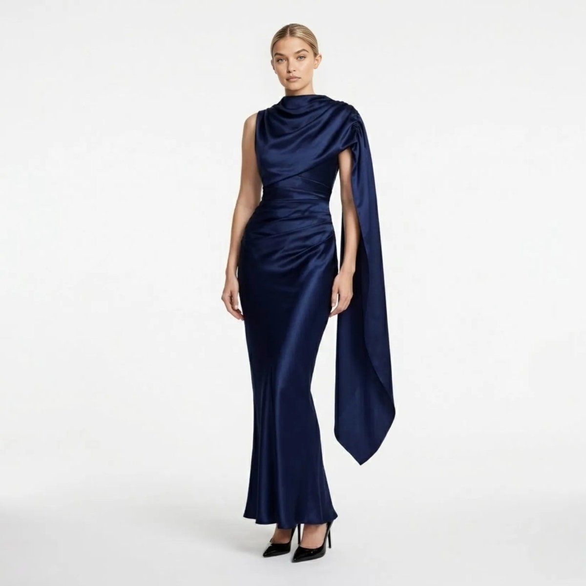 Front view of the Kouvr navy blue satin asymmetrical evening gown with draped cape sleeve and ruched bodice.
